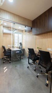 Glass-partitioned private cabins with desks and chairs at Linked Offices, Camac Street